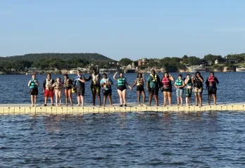 Kamp K'aana participants posing at deck for a photo