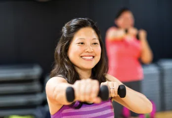 Lady holding weights during group exercise class
