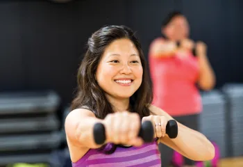 Lady holding weights during a group exercise class