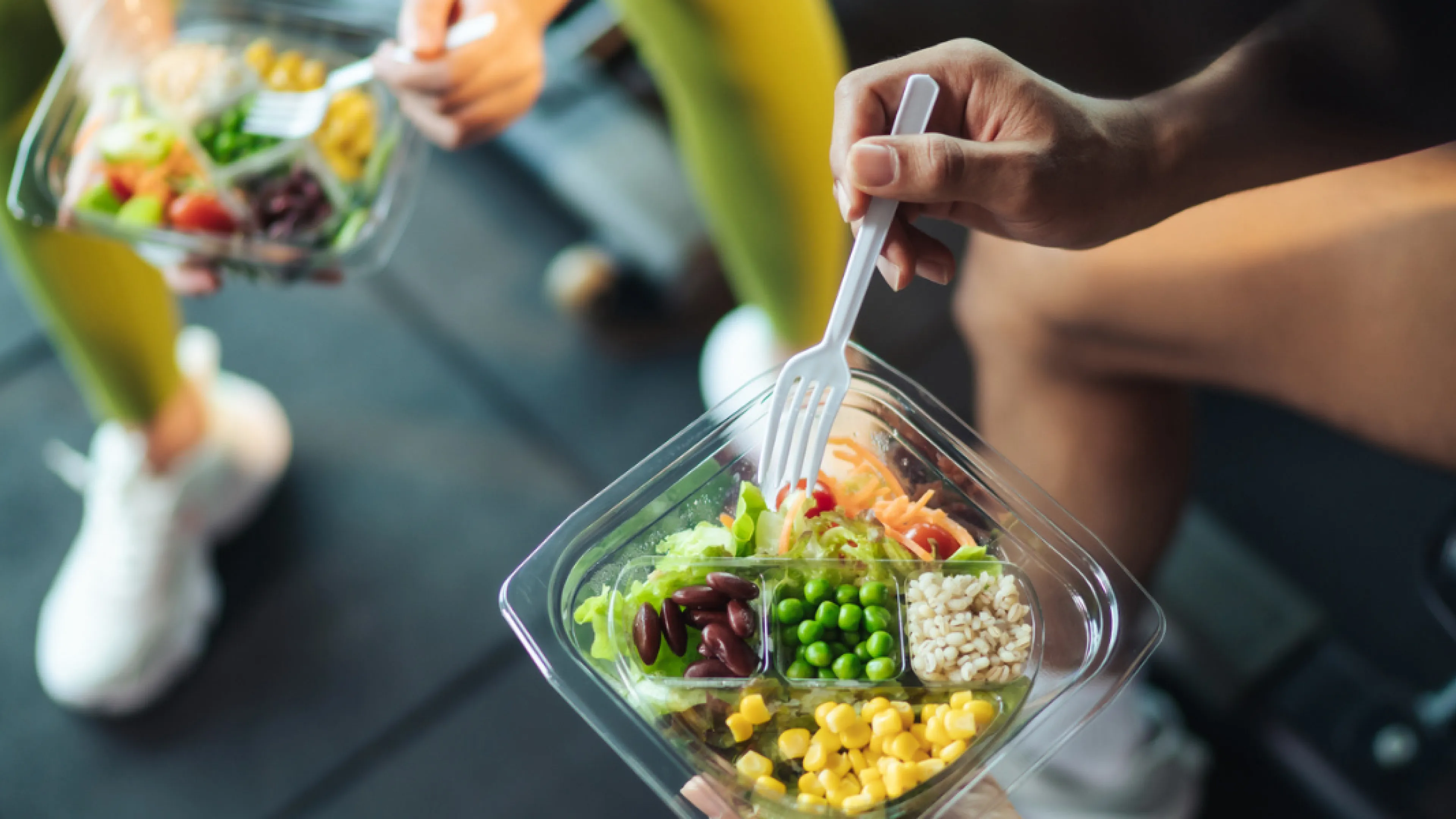 Two people eating a healthy meal in the gym