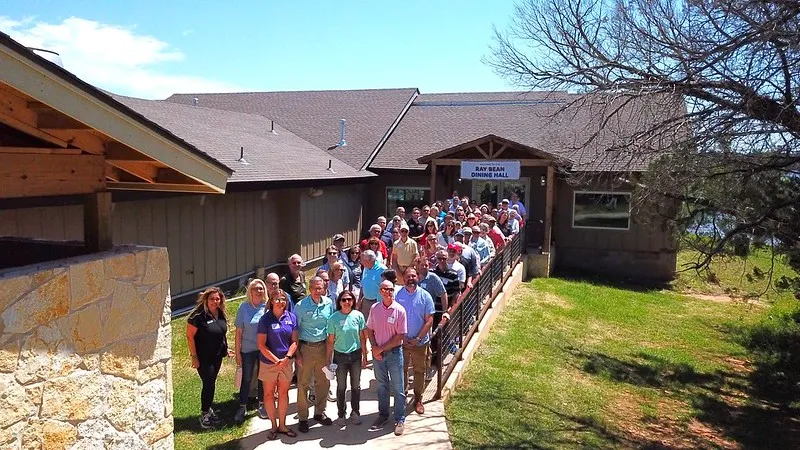 YMCA leadership, staff, and board members posing for a photo outside Ray Bean Dining Hall