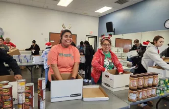 Two woman sorting food for Catalyst Christmas event