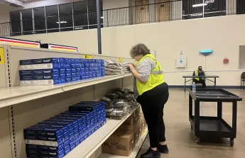 Teenager works to restock food before the market opens
