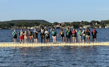 Kamp K'aana participants posing at deck for a photo