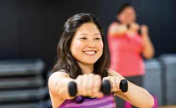 Lady holding weights during group exercise class
