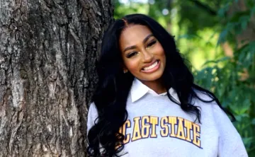 Alexis Williams posing in front of a tree